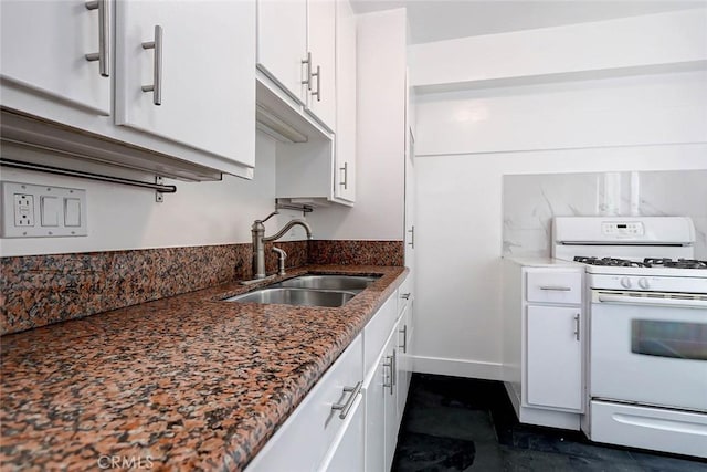 kitchen with sink, white cabinets, white gas stove, and dark stone counters