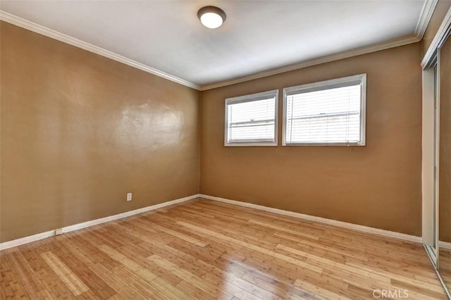 empty room with ornamental molding and light wood-type flooring