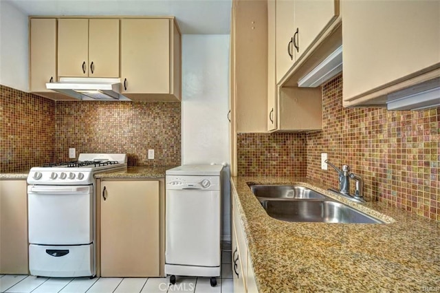 kitchen featuring white appliances, tasteful backsplash, sink, light tile patterned floors, and cream cabinetry