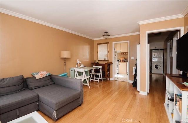 living room with ceiling fan, ornamental molding, stacked washer / drying machine, and light hardwood / wood-style flooring