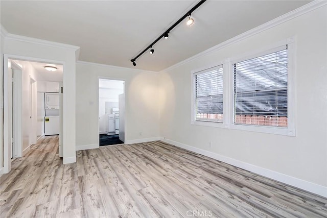 interior space featuring light wood-type flooring, crown molding, and rail lighting