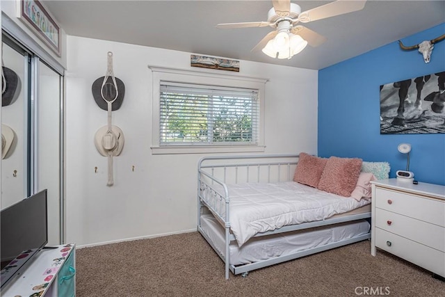 bedroom featuring ceiling fan and dark carpet