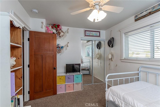 carpeted bedroom featuring ceiling fan and a closet