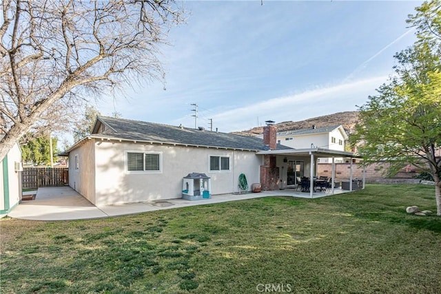 back of house featuring a patio area and a yard