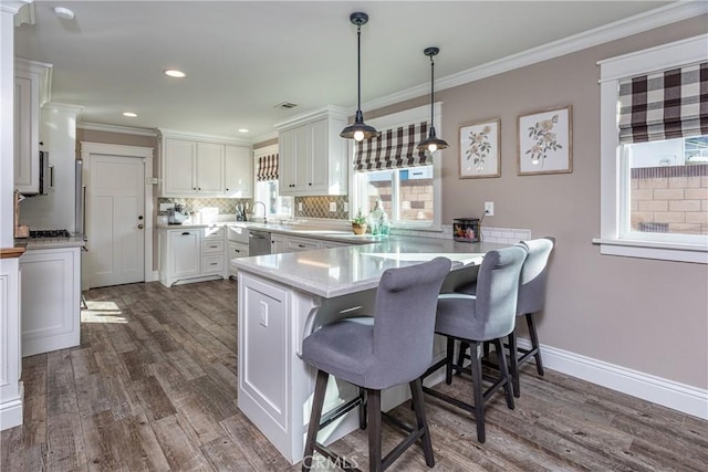 kitchen with kitchen peninsula, decorative backsplash, dark wood-type flooring, hanging light fixtures, and white cabinets