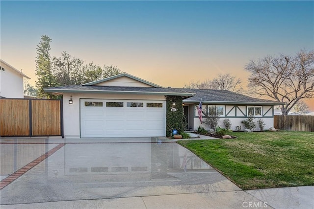 view of front of property with a garage and a yard