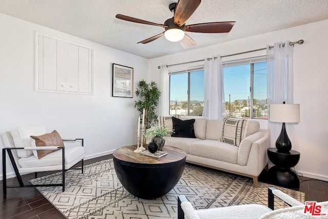 living room with ceiling fan and a textured ceiling