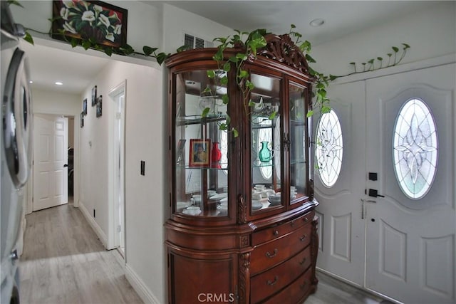 entrance foyer with a barn door and light hardwood / wood-style flooring