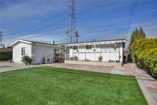 back of house with ac unit and a yard