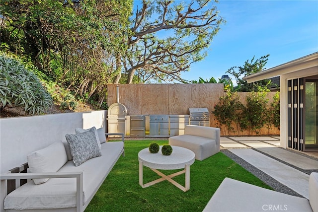 view of patio / terrace with an outdoor living space, exterior kitchen, fence, and grilling area