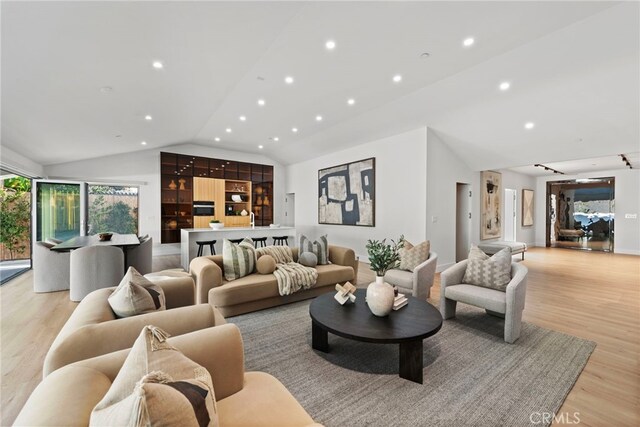 living room with light hardwood / wood-style flooring and vaulted ceiling