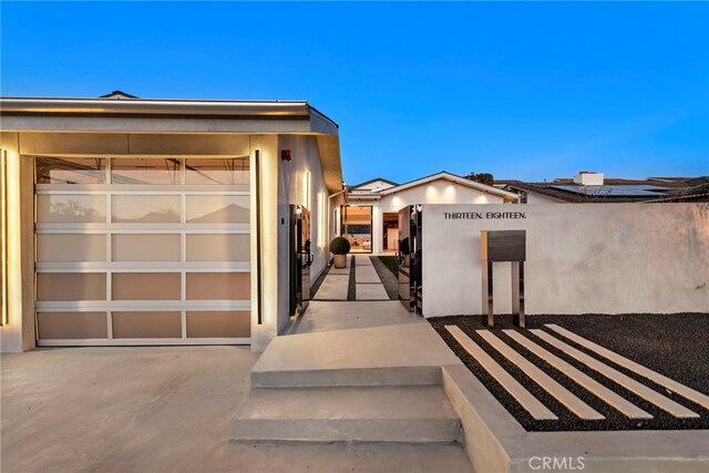 exterior entry at dusk with a garage