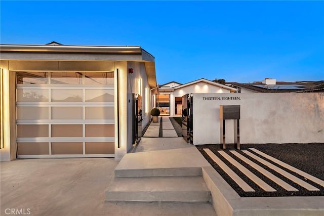 exterior entry at dusk with a garage