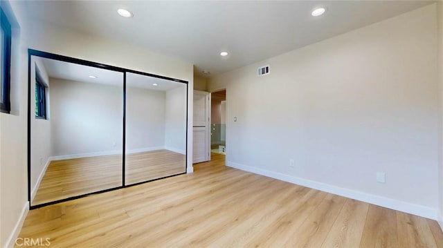 unfurnished bedroom with light hardwood / wood-style floors and a closet