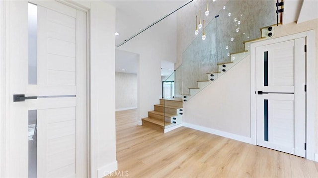 stairs featuring hardwood / wood-style floors and a towering ceiling