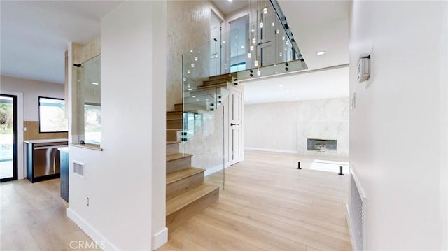 stairway featuring a premium fireplace and wood-type flooring