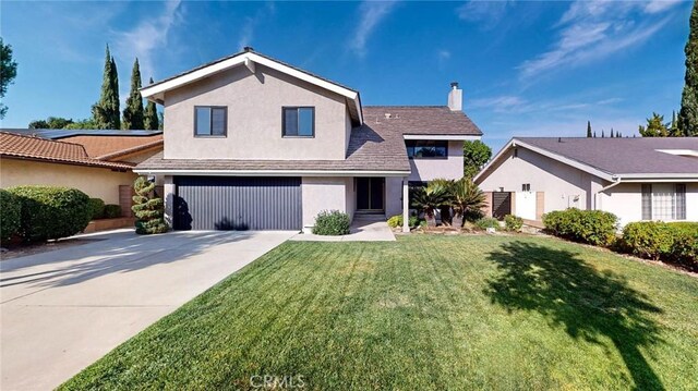 view of front of property featuring a front yard and a garage