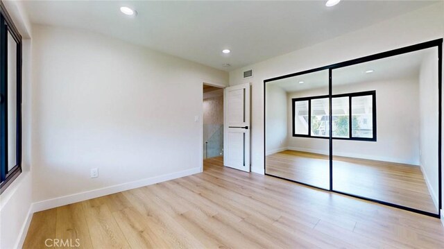 unfurnished bedroom with light hardwood / wood-style floors and a closet