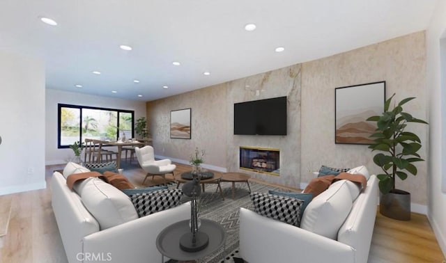 living room featuring a high end fireplace and light hardwood / wood-style floors