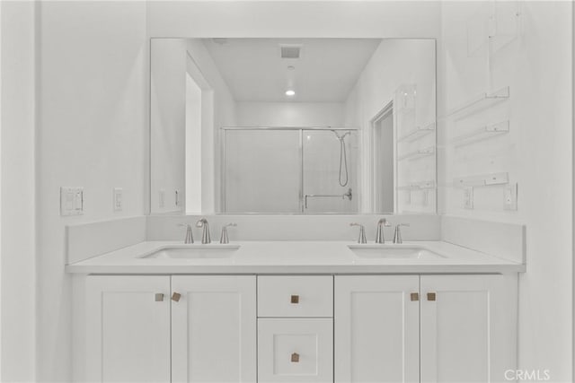 bathroom with vanity and a shower with door