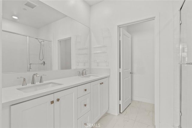 bathroom featuring a shower with shower door and vanity