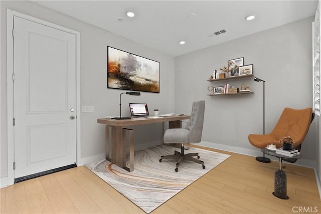 home office with light hardwood / wood-style flooring