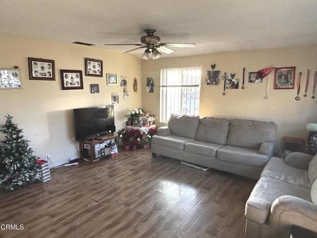 living room with ceiling fan, a textured ceiling, and dark hardwood / wood-style flooring