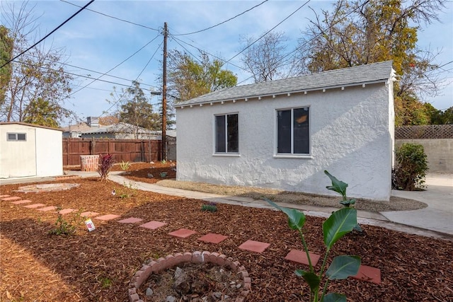 view of side of home with a storage shed