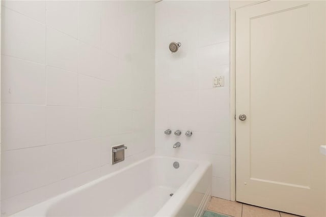 bathroom with tile patterned floors and a tub to relax in