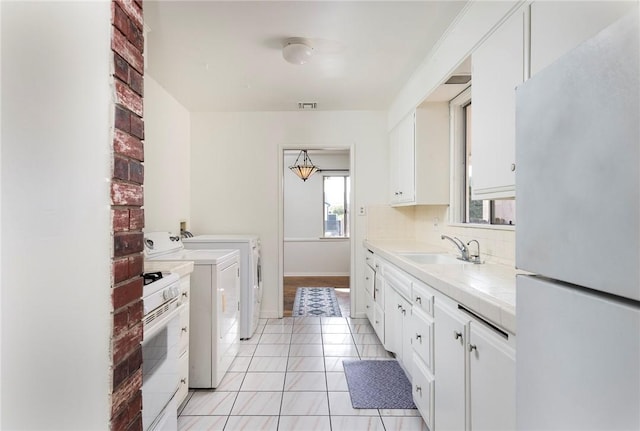 laundry area with light tile patterned flooring, sink, and washer and clothes dryer