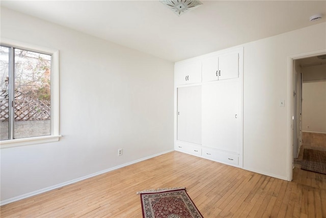 unfurnished bedroom featuring light hardwood / wood-style floors and a closet