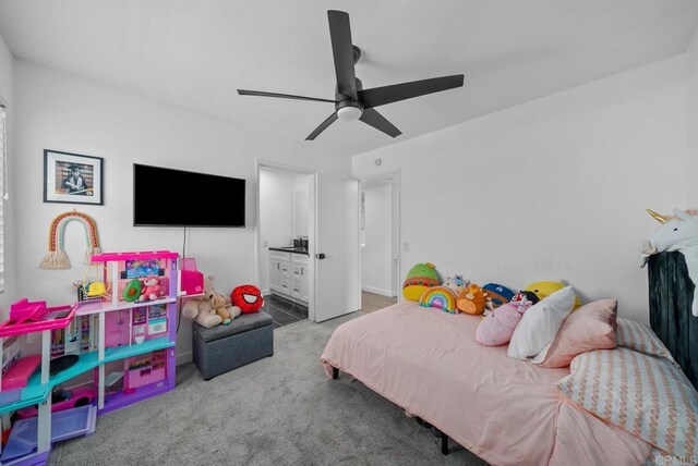 carpeted bedroom featuring ensuite bath and ceiling fan