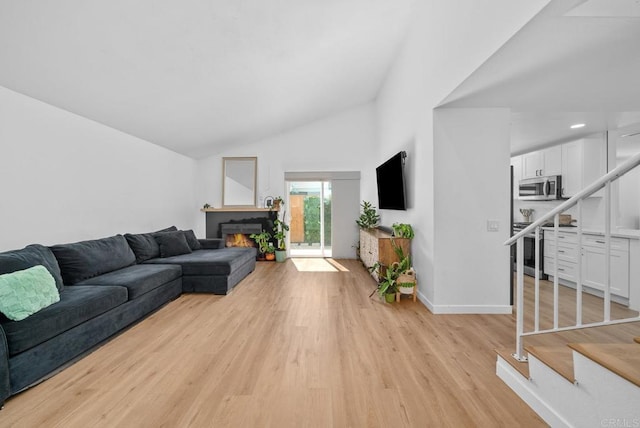 living room with high vaulted ceiling and light wood-type flooring