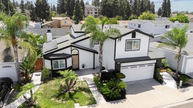 view of front of house with a garage and solar panels