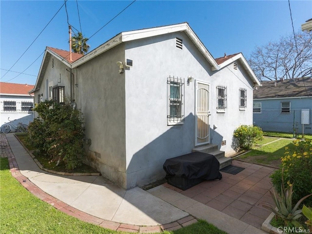 view of side of property featuring a patio area and a yard