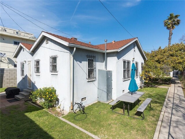 rear view of property featuring a lawn