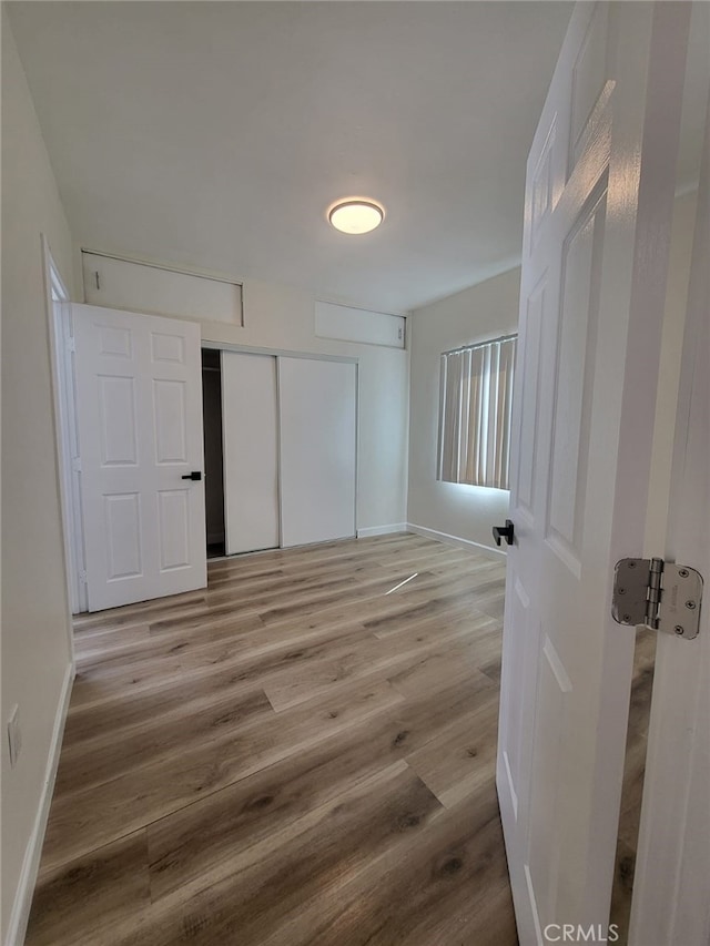 unfurnished bedroom with a closet and light wood-type flooring