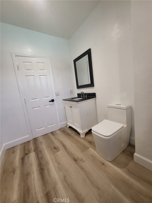 bathroom featuring toilet, wood-type flooring, and vanity