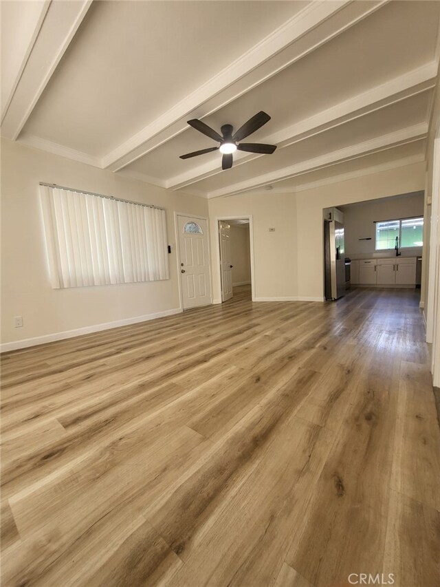 unfurnished living room featuring ceiling fan, light hardwood / wood-style floors, and beam ceiling