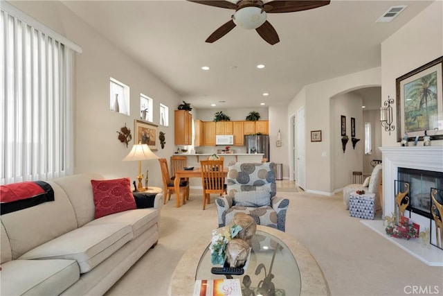 carpeted living room with ceiling fan