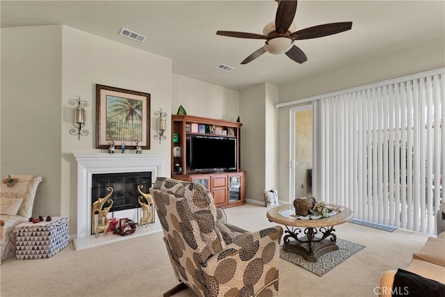 carpeted living room with ceiling fan