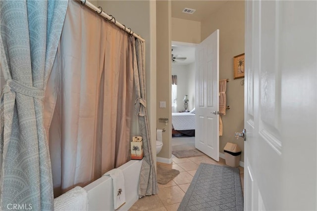 bathroom with ceiling fan, toilet, shower / bathtub combination with curtain, and tile patterned flooring