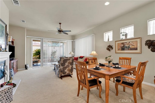 carpeted dining space with ceiling fan