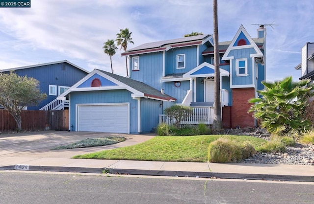 view of front facade with a front yard, a garage, and solar panels