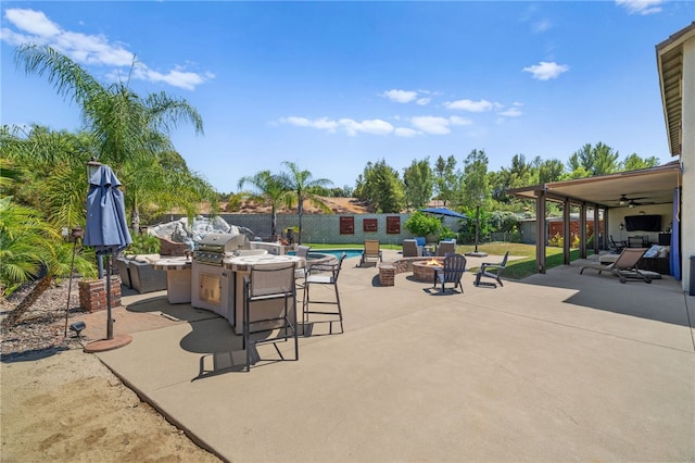 view of patio featuring a fenced in pool, a fire pit, and ceiling fan