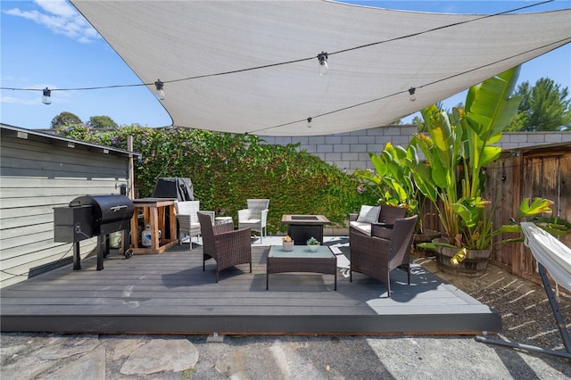 wooden terrace featuring an outdoor living space and area for grilling