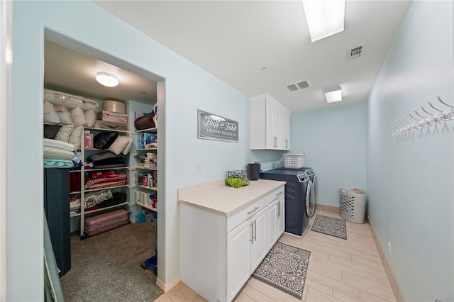 washroom featuring cabinets and separate washer and dryer