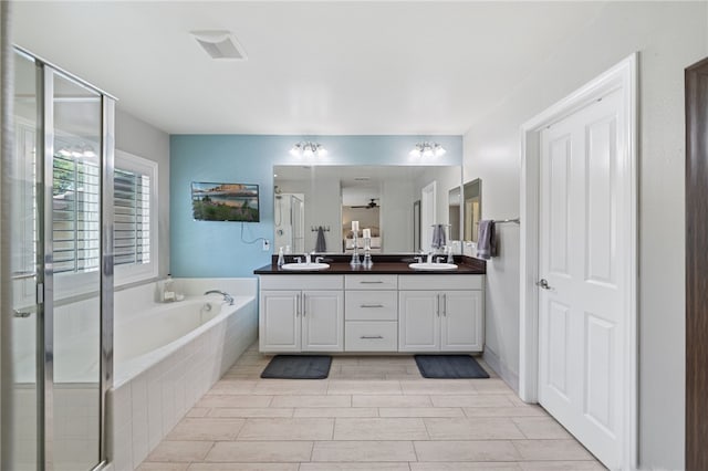 bathroom with vanity and shower with separate bathtub