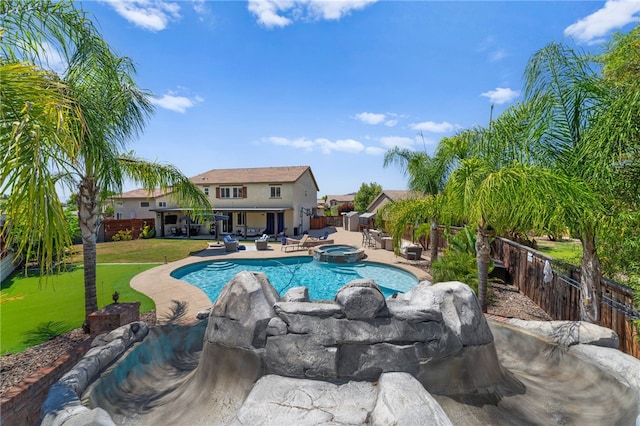 view of swimming pool featuring an in ground hot tub, a lawn, and a patio