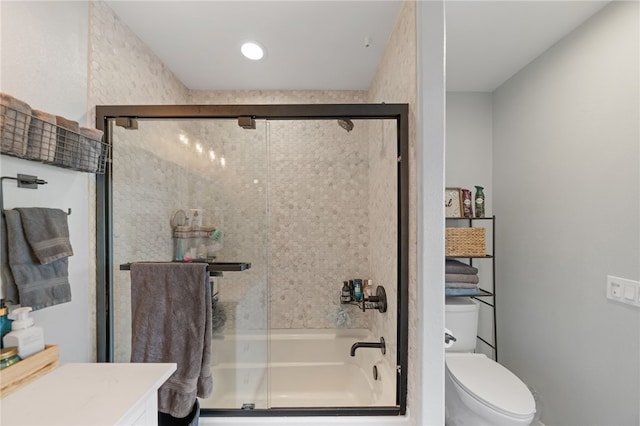 full bathroom featuring toilet, bath / shower combo with glass door, and vanity